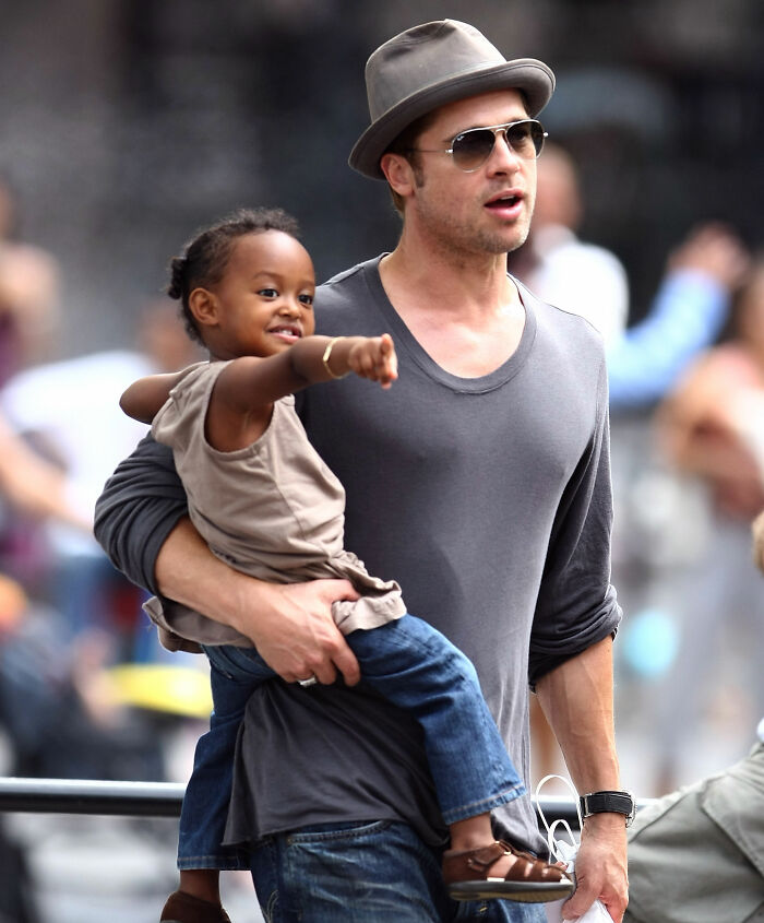 Brad Pitt carrega criança na rua Brad Pitt carrega criança na rua