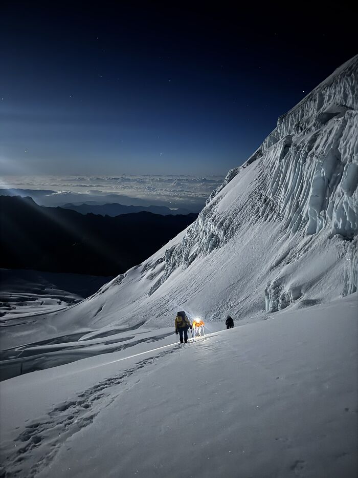 Mountain climbers ascending icy slope under starry sky stunning alpine views