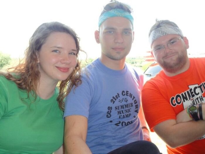 Three friends posing together wearing casual summer clothes
