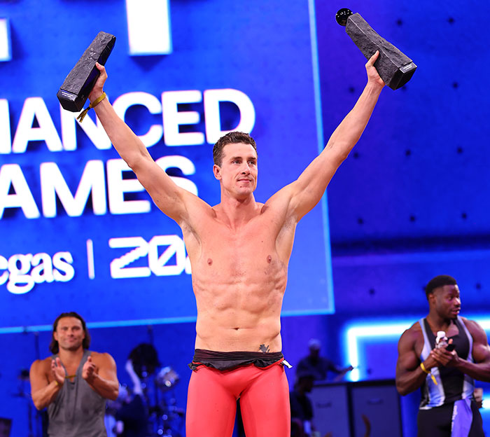 Winner holding trophies at Steroid Olympics event on stage