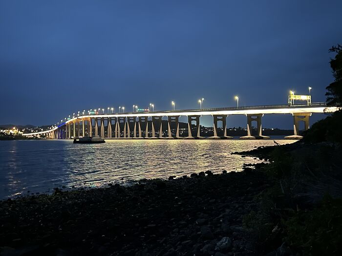 Night view of a brightly illuminated bridge extending across water