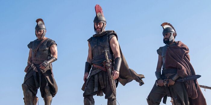 Three warriors in The Odyssey movie costumes standing against clear sky