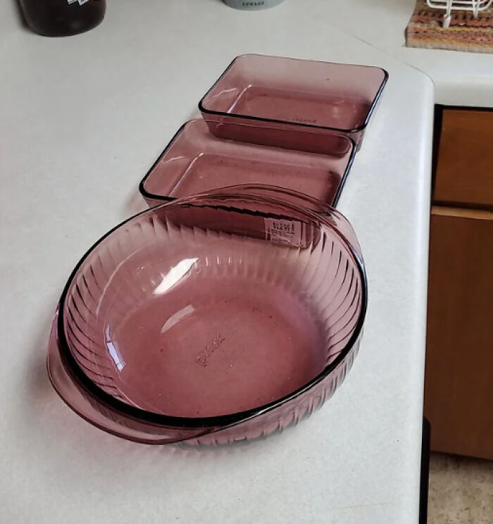 Three purple Pyrex baking dishes, varying in size, showcasing a "Glitches In The Matrix" aesthetic on a countertop.