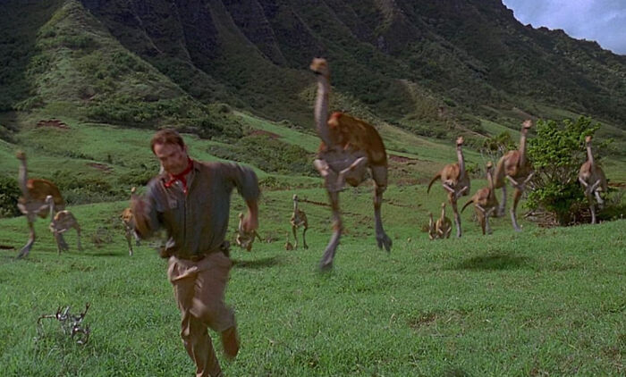 Scene from movie showing man running from dinosaurs