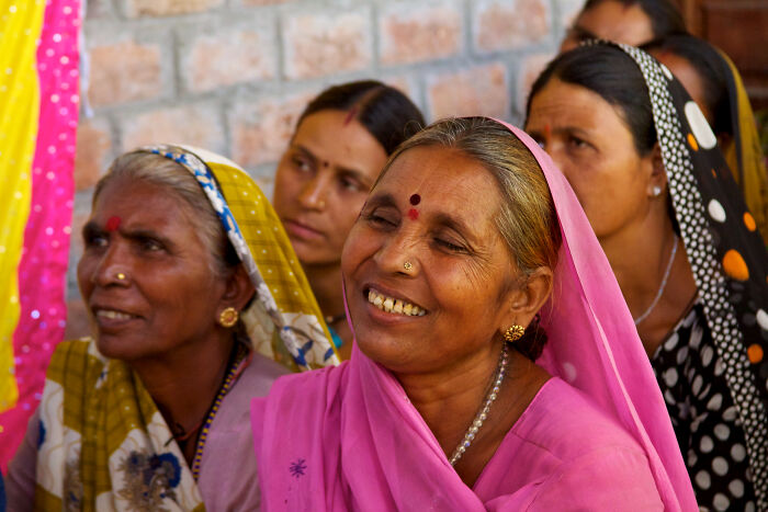 Group of women in bright pink sarees fighting back in rural India history
