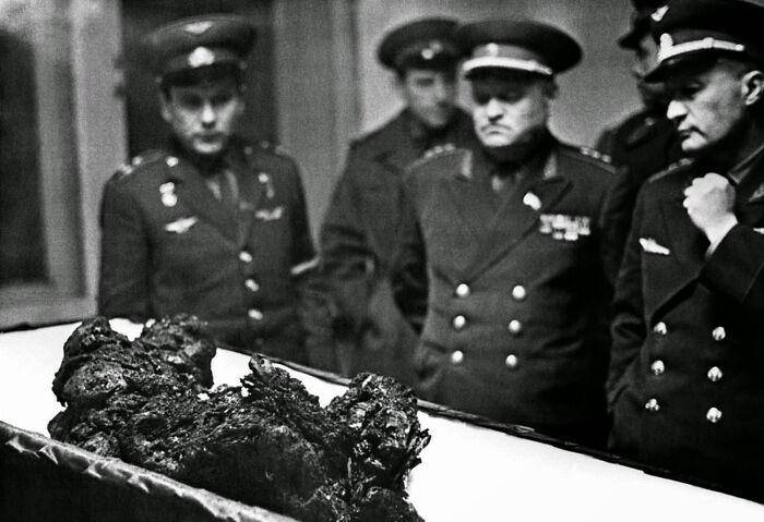 Vintage photo of officers examining strange charred remains