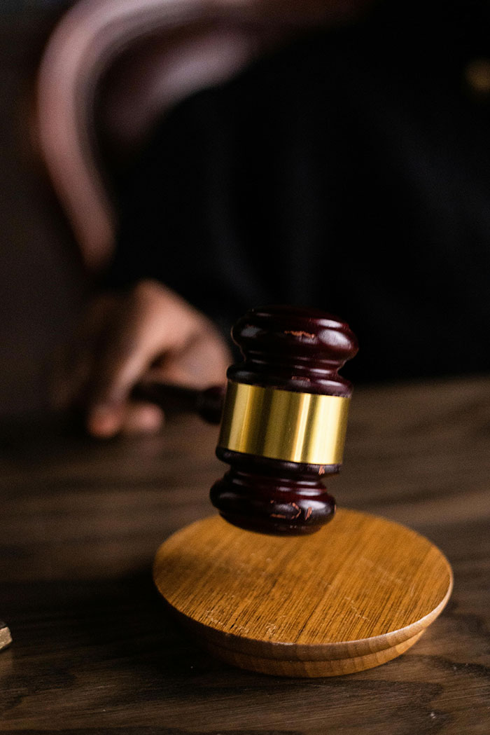 Close-up of judge's gavel striking wooden block for legal action