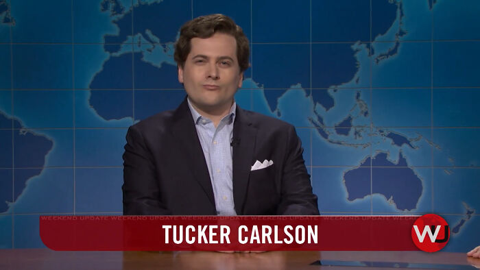 A man resembling Tucker Carlson in a suit, against a world map, discussing Statue Of Liberty Met Gala outfits. A man resembling Tucker Carlson in a suit, against a world map, discussing Statue Of Liberty Met Gala outfits.