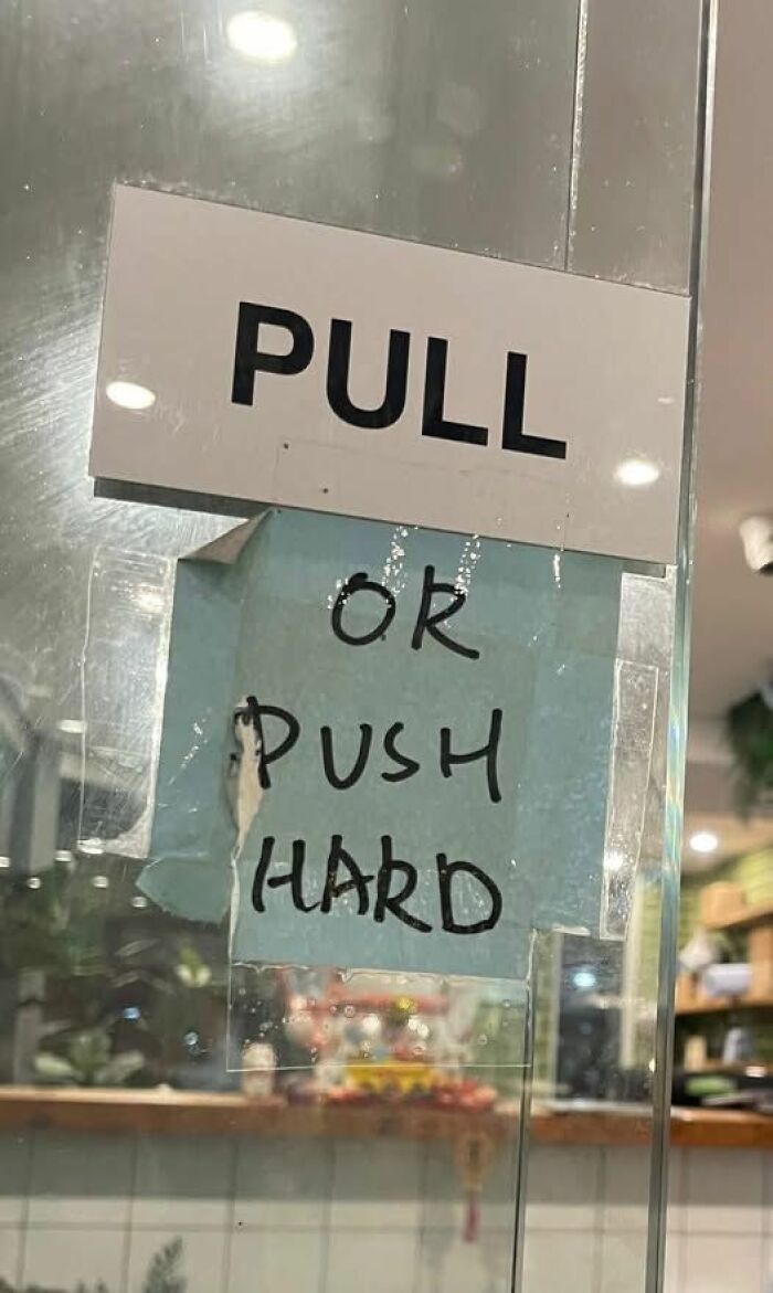 Confusing door signs say pull or push hard in handwritten note