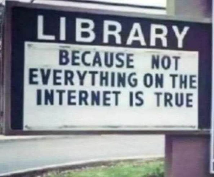 Library sign humorously stating not everything on the internet is true