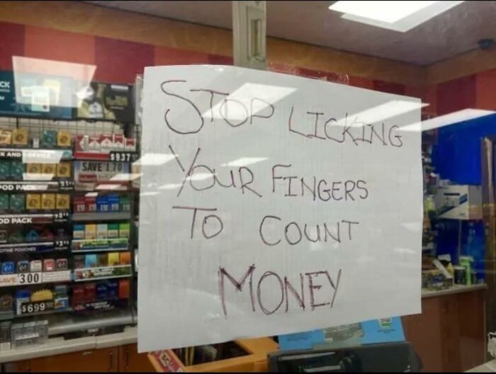 Humorous handwritten sign telling customers to stop licking fingers to count money