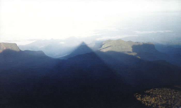 Mountain casting a perfect pyramid shadow at sunrise