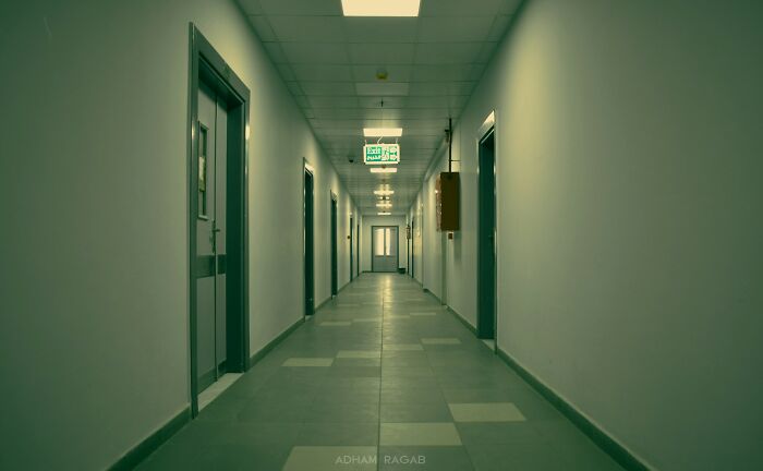 Empty, sterile hallway inside a psychiatric facility with closed doors