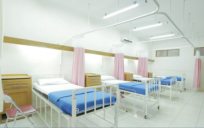Clean hospital ward with multiple beds and privacy curtains