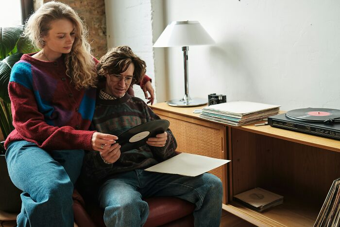 Couple examining vinyl records at home, depicting shared hobbies of long term partners