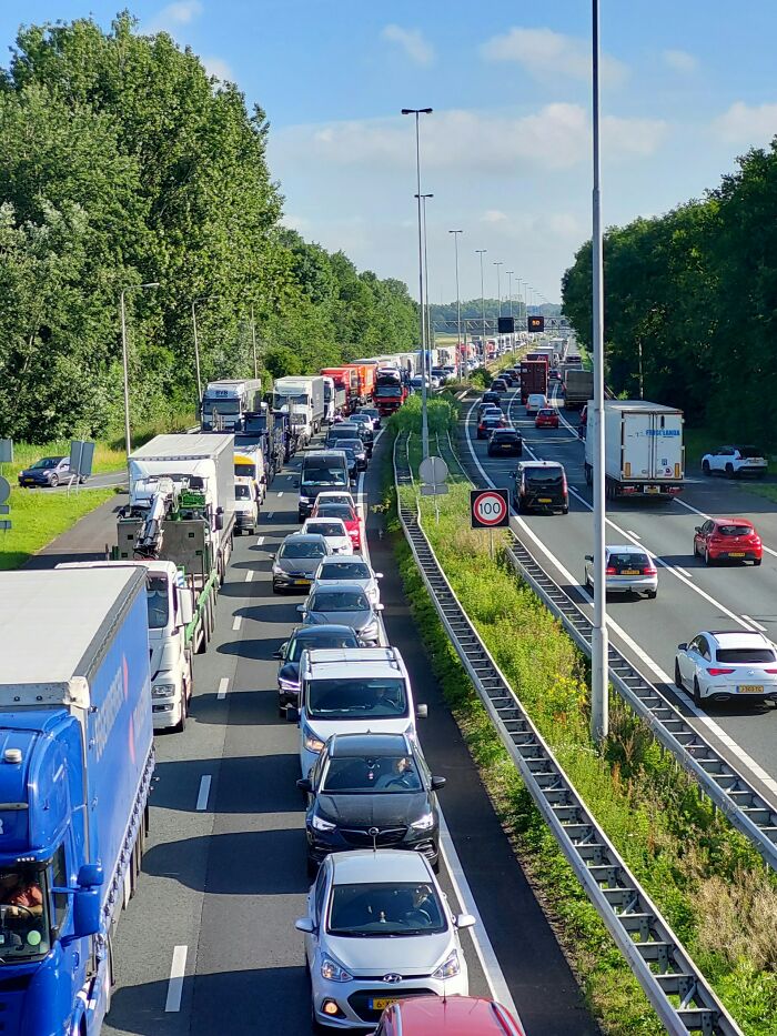 Heavy traffic jam with trucks and cars on a busy highway surrounded by greenery