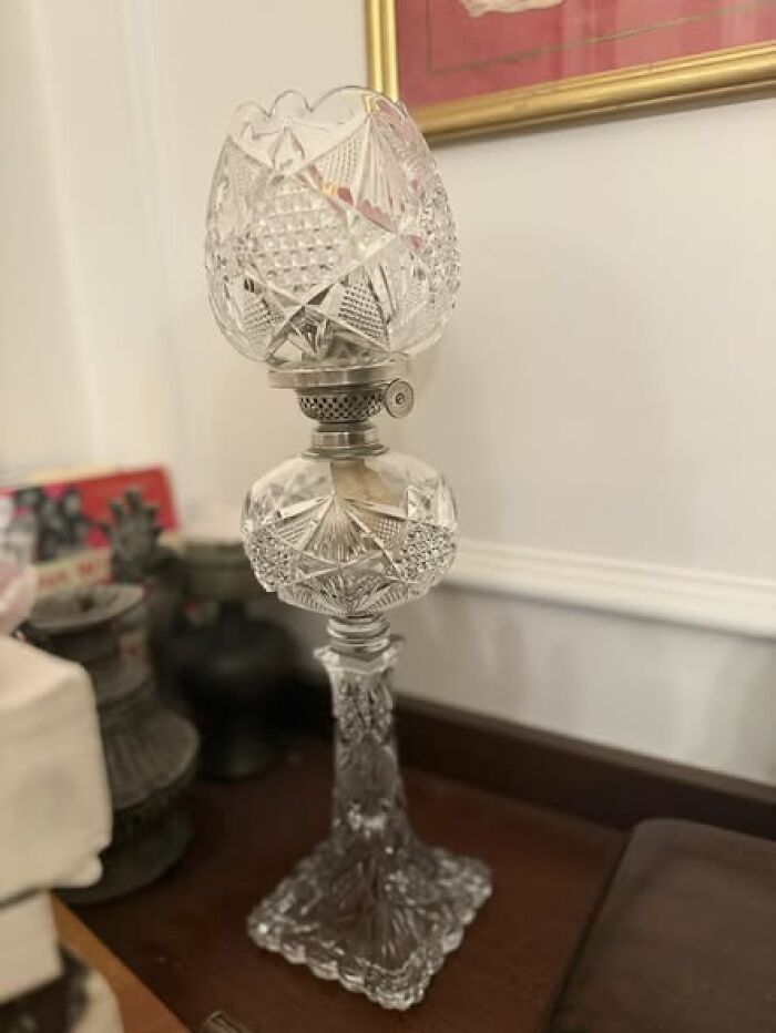 Cut glass vintage secondhand lamp with ornate square base on wooden surface