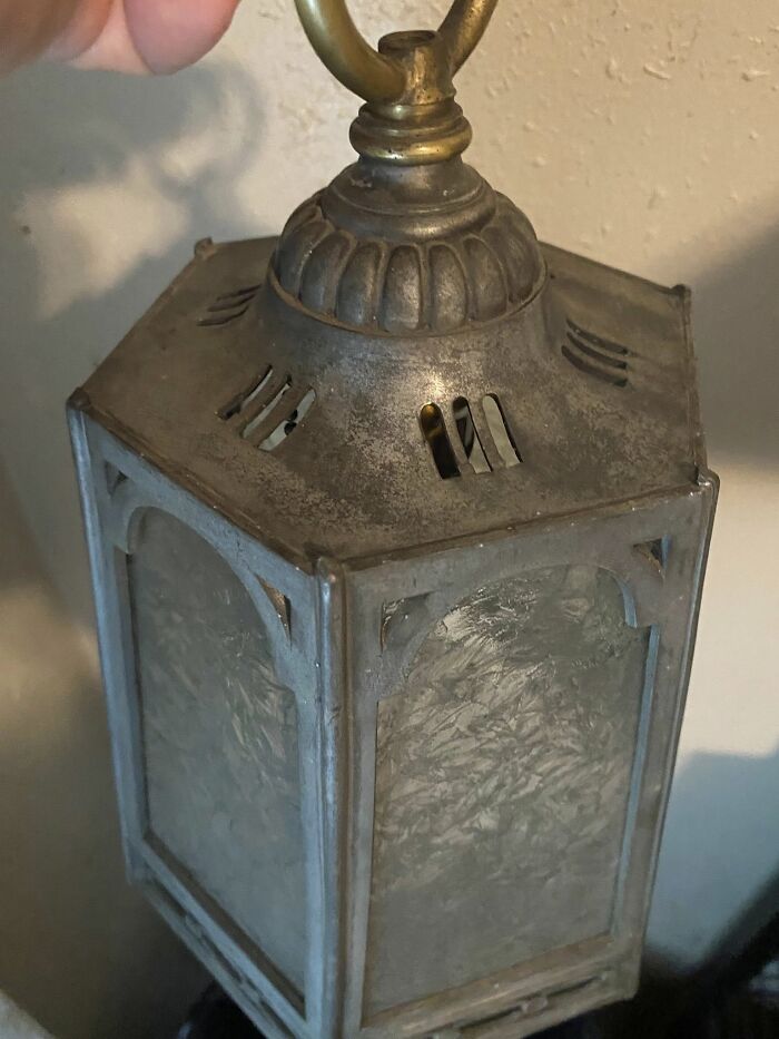 Rustic vintage metal lantern with frosted glass panels hanging indoors