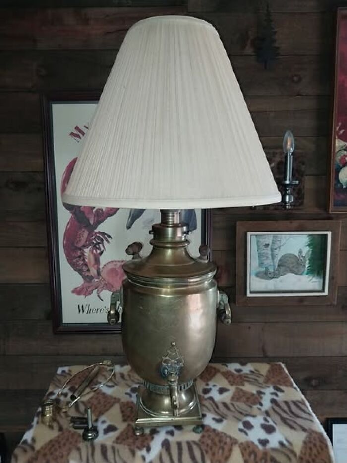 Vintage secondhand lamp with brass base and white pleated shade on a patterned cloth