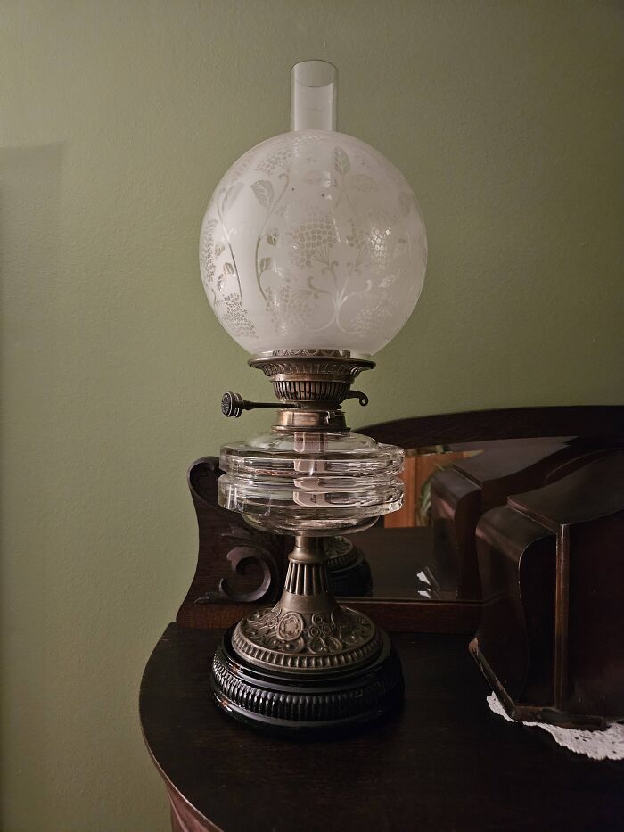 Antique vintage secondhand glass lamp with etched floral globe on wooden table