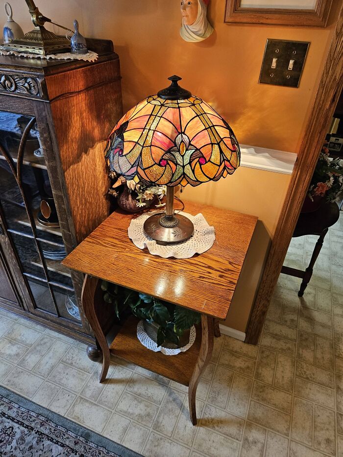 Tiffany-style vintage secondhand lamp with stained glass shade on wooden side table