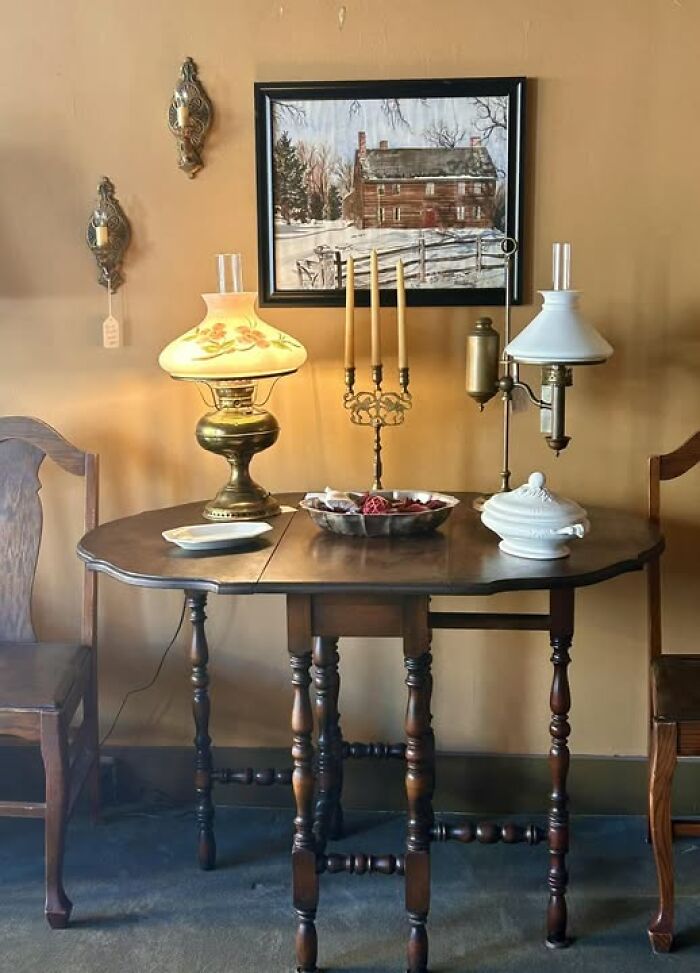Set of vintage secondhand oil lamps on wood dining table with candles and decor