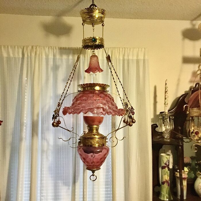 Pink glass vintage secondhand hanging lamp with brass accents in vintage room
