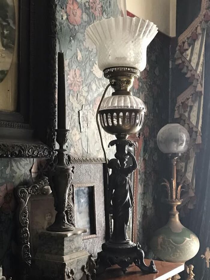 Old vintage lamp with carved dark metal base and frosted fluted glass shade