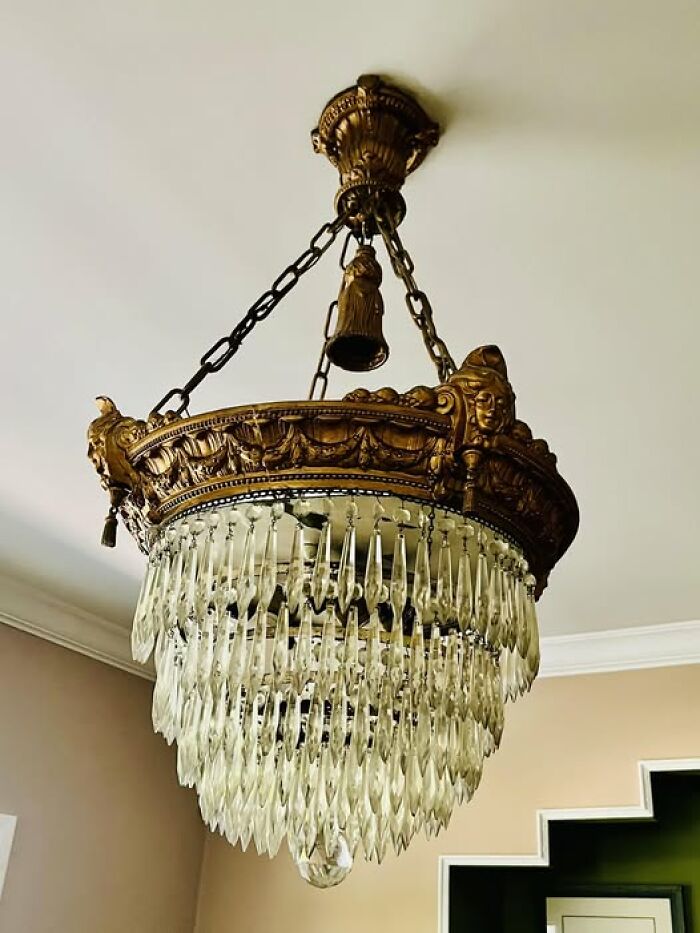 Elegant vintage crystal chandelier with gold-toned frame suspended from ceiling