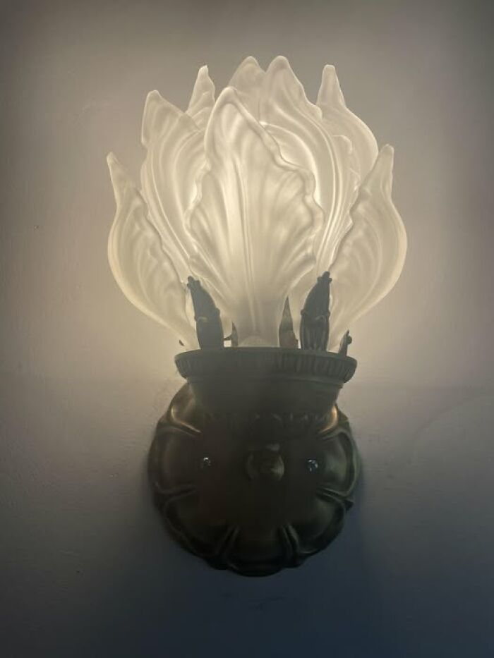 Vintage secondhand decorative glass wall sconce lamp glowing softly