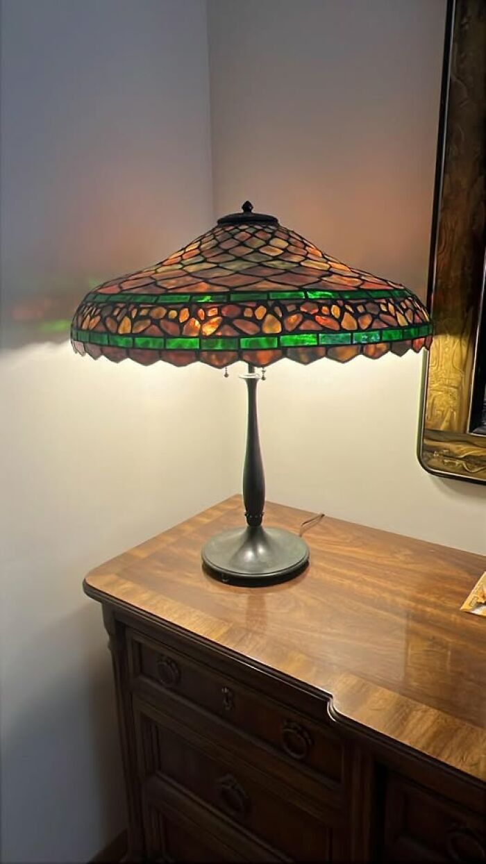Vintage secondhand stained glass Tiffany style table lamp on wooden dresser