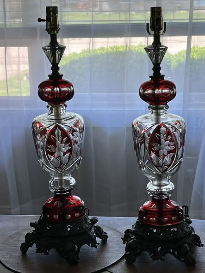 Pair of vintage secondhand lamps with red and clear glass and ornate black metal bases