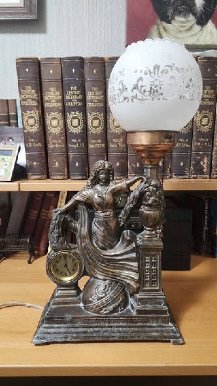 Vintage secondhand lamp with clock and figure of a woman holding a globe