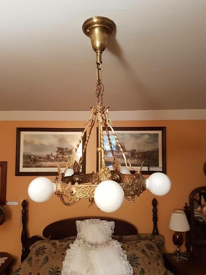 Victorian-style vintage chandelier with four white globe lights