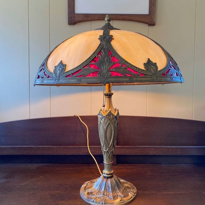 Antique vintage lamp with red and amber stained glass shade and decorative base