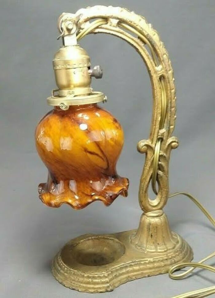 Vintage secondhand lamp with ornate brass frame and amber glass shade