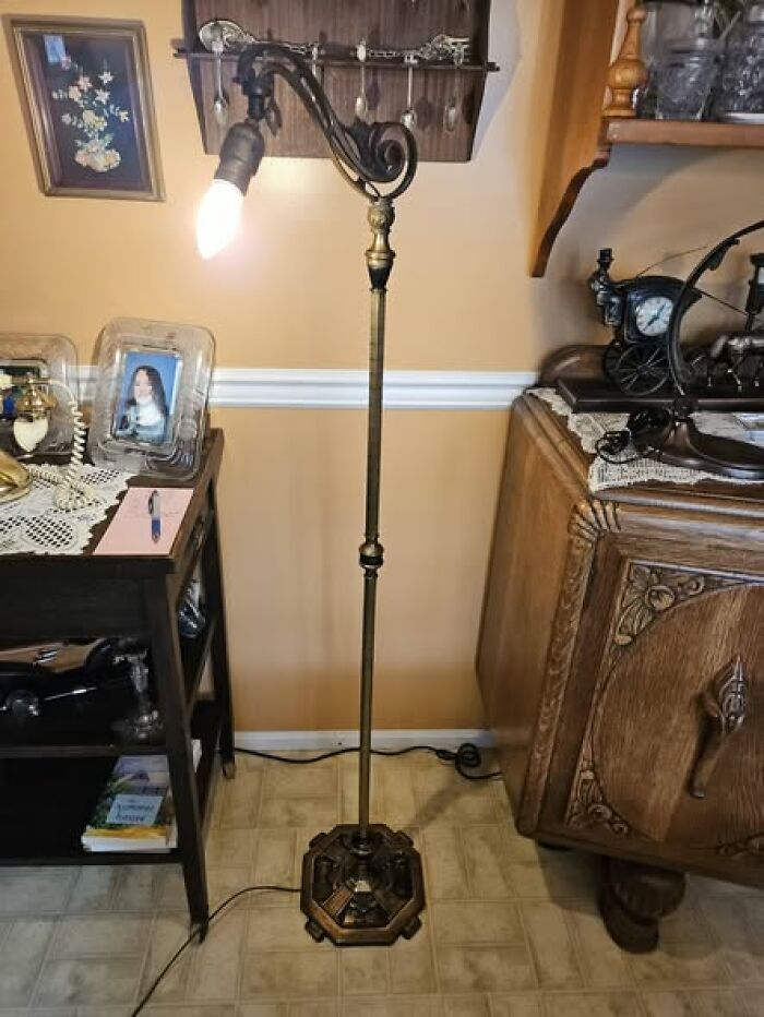 Tall vintage secondhand floor lamp with scroll metal arm and exposed bulb