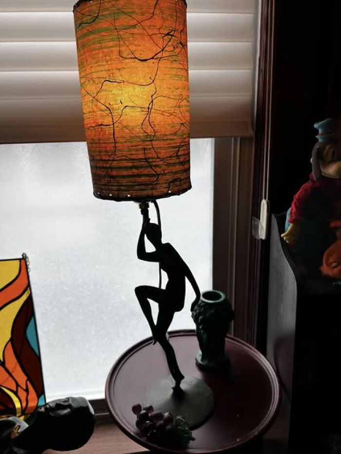 Mid-century vintage secondhand lamp with orange textured cylindrical shade and figure base