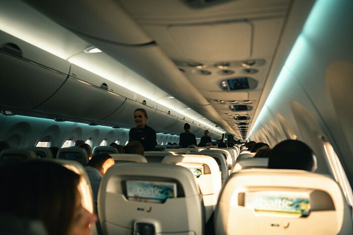 Flight attendants serving passengers inside an airplane cabin