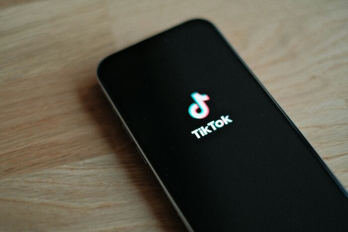 Smartphone displaying the TikTok logo, representing things Gen Z does that older generations don't understand.