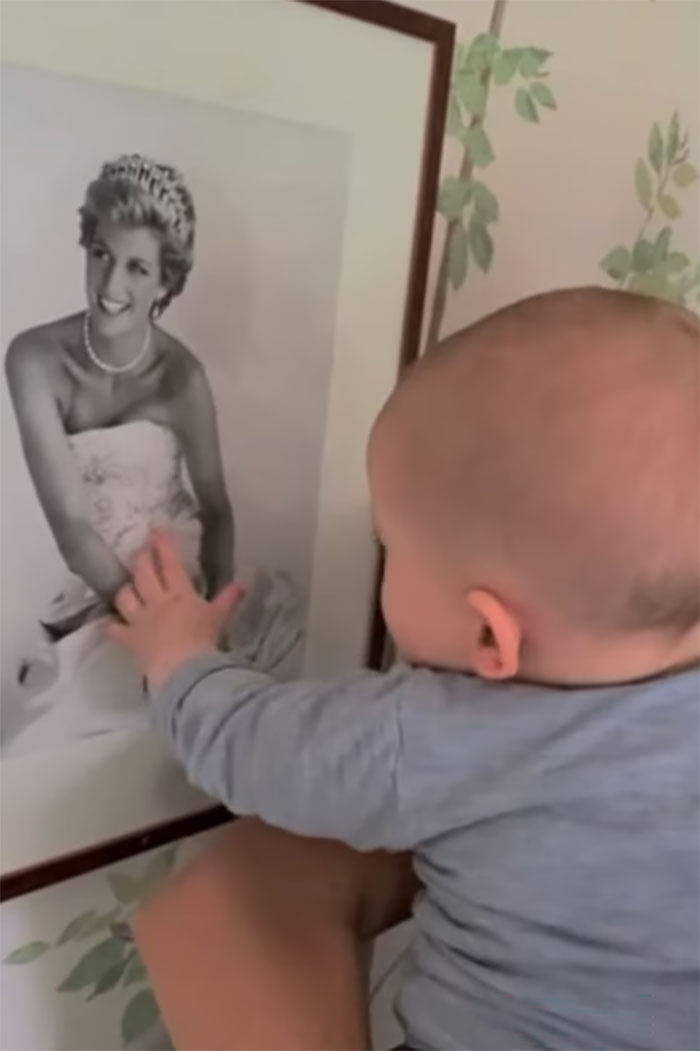 Baby Prince Archie reaching for a framed black-and-white photo of Princess Diana. People pick out odd details.