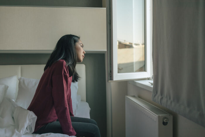 Woman looking out window in psychiatric facility room