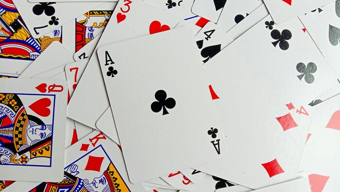 Scattered playing cards with aces visible for shocking facts