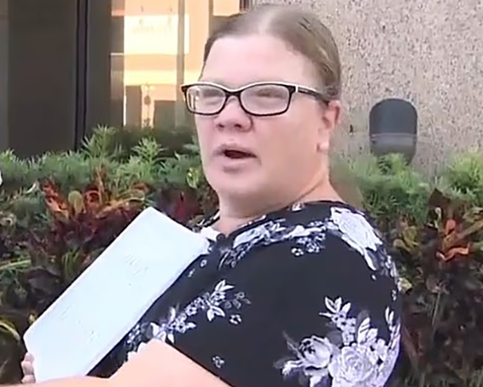 Christian mom in glasses holding paper outdoors near building Christian mom in glasses holding paper outdoors near building