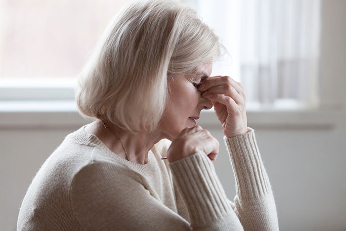 Stressed middle-aged woman showing frustration indoors Stressed middle-aged woman showing frustration indoors