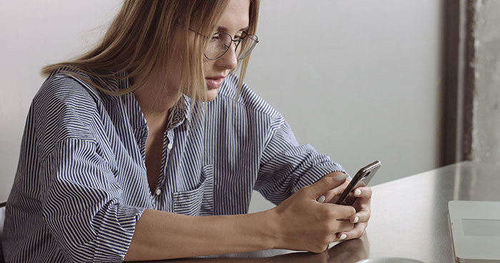 Woman plotting perfect revenge on toxic mom while using smartphone