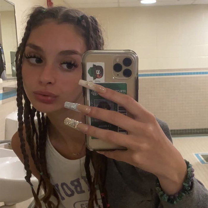 Selfie of Mackenzie Shirilla in a bathroom with braided hair and long nails