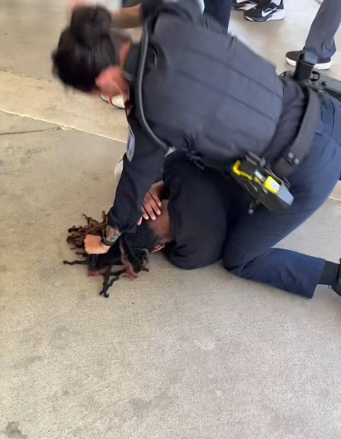 Female cop aggressively restraining high school boy on ground during arrest Female cop aggressively restraining high school boy on ground during arrest