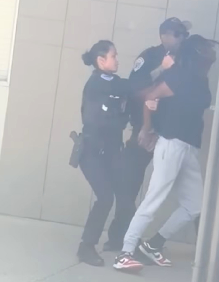 Female police officer making an arrest of a man in casual clothes outdoors Female police officer making an arrest of a man in casual clothes outdoors