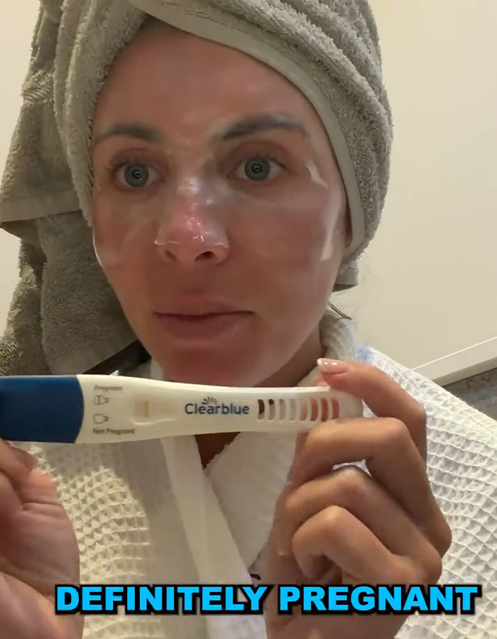 Bonnie Blue in bathrobe showing positive Clearblue pregnancy test